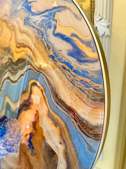 Close-up van Ocean Breeze: stromingen van blauw, goud en karamel in de epoxy, met een gouden rand